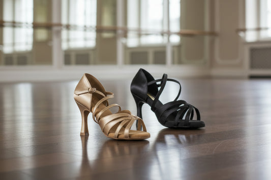 Nude and black strappy high-heeled shoes on a white background